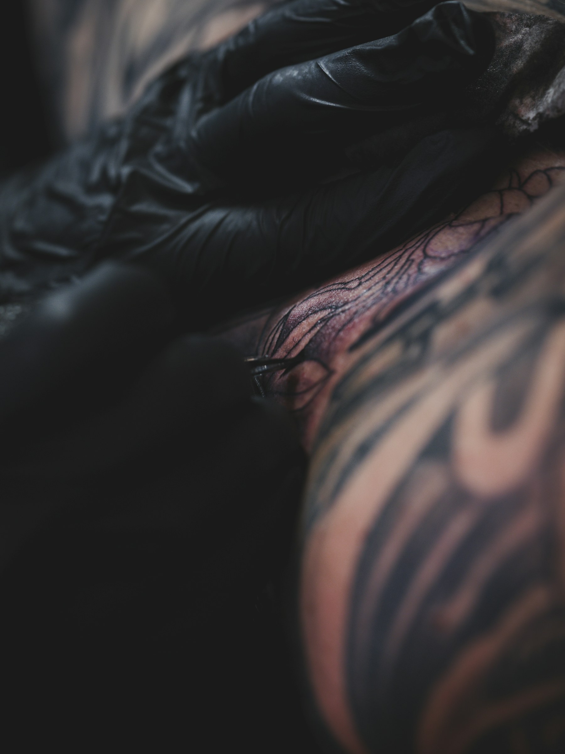 Tattoo artist working on a detailed neck tattoo